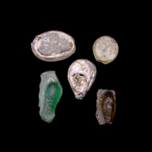 a-group-of-5-(five)-early-islamic-glass-vessel-stamps,-two-examples-moulded-in-the-form-of-a-human-face_08537b